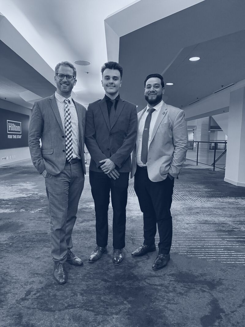 Three Icarus Acquisitions leaders in suits at a national conference