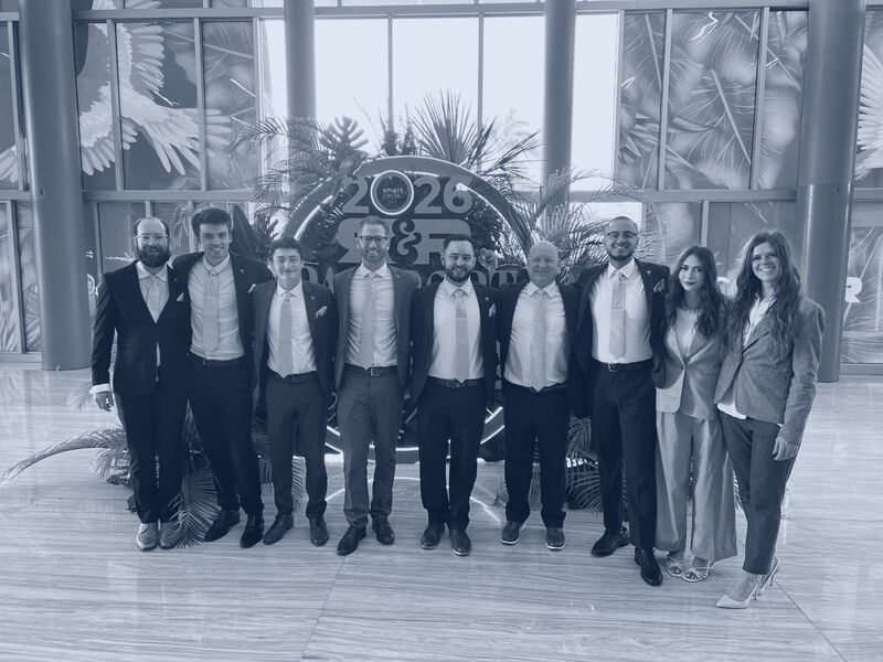 The Icarus Acquisitions team in navy suits and gold ties at a national sales conference