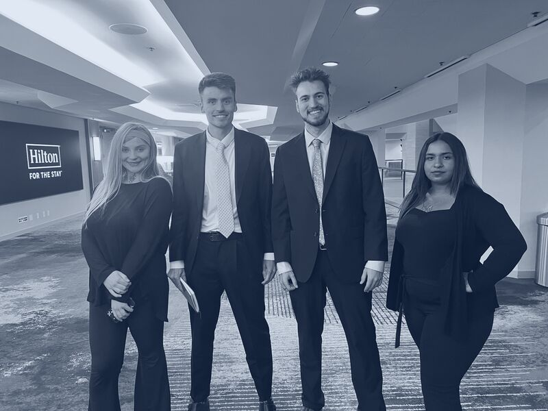 Four Icarus Acquisitions representatives in professional business attire at a hotel event